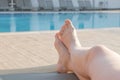 Legs of an elderly woman on a sun lounger against the background of the pool Royalty Free Stock Photo