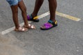 Legs and feet of African American father and daughter wearing summer colorful sandals and shorts Royalty Free Stock Photo