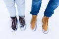 Legs and feet of couple in love in stylish shoes in snow