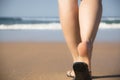 Legs and feet of a girl walking towards the sea