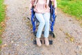 Legs feet handicap woman in wheelchair wheel on road in hospital park waiting for patient services. Unrecognizable paralyzed girl Royalty Free Stock Photo