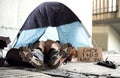 Legs and feet of homeless beggar man lying on the ground in city, sleeping in tent. Royalty Free Stock Photo