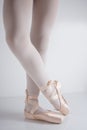 Legs and feet with pink satin pointe shoes by a classical dancer posing