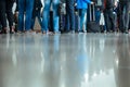 Legs feet stand landing gate bags baggage people airport terminal travel departure nether man many reflections floor