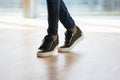 Legs and feet in trendy stylish sneakers of young man