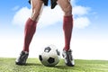 Legs of football player in red socks and black shoes running and dribbling with ball playing outdoors Royalty Free Stock Photo