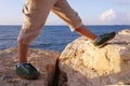 Legs of giant boy, step on stones, sea Royalty Free Stock Photo