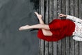 Legs of a girl in a red skirt on a bridge Royalty Free Stock Photo