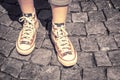 Legs of girl in gumshoes on pavement