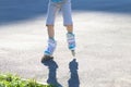 Legs of girl roller skating on playground