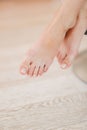 Legs of a girl sitting on a chair in a room with a French pedicure. Close-up