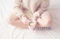 Legs of girl warm woolen socks and cup of coffee warming, winter morning in bed