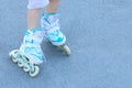 Legs of girl with white roller skates on asphalt outdoor