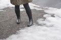 Legs of a girl in winter boots walking on a snowy road. Royalty Free Stock Photo