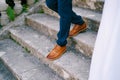 Legs of the groom descending the stairs next to the bride. Cropped. Faceless Royalty Free Stock Photo