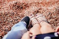 The legs of a guy and a girl in sandals in beach sand Royalty Free Stock Photo