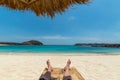 Legs of guy relaxing on beach under umbrella Royalty Free Stock Photo