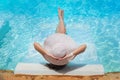 Legs and a hat of woman in the pool water Royalty Free Stock Photo