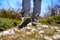 Legs of a hiker in trekking boots walking in the mountains closeup shot. Feet of walking tourist wearing trekking shoes