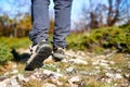 Legs of a hiker in trekking boots walking in the mountains closeup shot. Feet of walking tourist wearing trekking shoes