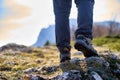 Legs of a hiker in trekking boots walking in the mountains closeup shot. Feet of walking tourist wearing trekking shoes