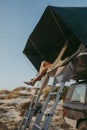 Legs inside a rooftent on top of a 4x4 car