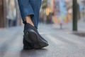 Legs with jeans and black canvas sneakers in the city Royalty Free Stock Photo