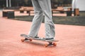 Legs in jeans and sneakers riding skateboard