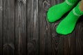 Legs knit green wool socks on wooden dark background. Royalty Free Stock Photo