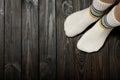 Legs knitted white woolen socks on wooden dark background. Royalty Free Stock Photo