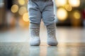 Legs of little baby in socks learning to walk at home, closeup. Infant first steps Royalty Free Stock Photo