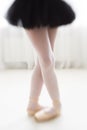 Legs of little balerina wearing pail pink pointe shoes with ribbons Royalty Free Stock Photo