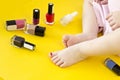 Legs of a little girl and cosmetics on a yellow background baby