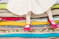 Legs of a little girl sitting on a pile of colorful mattresses. Decorations for the fairy tale The princess on a Pea