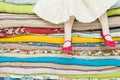 Legs of a little girl sitting on a pile of colorful mattresses. Decorations for the fairy tale The princess on a Pea