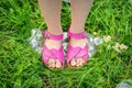 Legs of a little girl tramples a plastic bottle Royalty Free Stock Photo