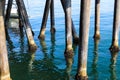 The legs of a long wooden pier in vast blue ocean water at Santa Monica Beach in Santa Monica Royalty Free Stock Photo