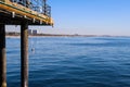 The legs of a long wooden pier in vast blue ocean water at Santa Monica Beach in Santa Monica Royalty Free Stock Photo
