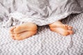 Legs of lovers under blanket. Happy couple having fun in bed. Royalty Free Stock Photo