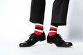 Legs of man in business pants and shoes with funny red, black and white striped socks Royalty Free Stock Photo