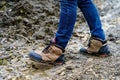 Legs of a man in jeans and winter boots against the backdrop of impenetrable mud. Problems in the rainy season Royalty Free Stock Photo