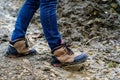 Legs of a man in jeans and winter boots against the backdrop of impenetrable mud. Problems in the rainy season Royalty Free Stock Photo