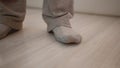 Legs of a man in socks at home on a light laminate