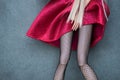 legs of mannequin doll wearing sexy tights and red dress on grey background