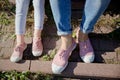 Legs of mom and daughter sitting on the steps in pink sneakers and jeans Royalty Free Stock Photo