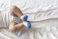 Legs of 6-8-month-old baby boy in white bodysuit playing in his bed. Copy space Royalty Free Stock Photo