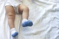 Legs of 6-8-month-old baby boy in white bodysuit playing in his bed. Copy space Royalty Free Stock Photo