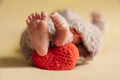 Legs of a newborn. Baby feet with a crochet heart. The tiny foot of a newborn in soft selective focus. Royalty Free Stock Photo