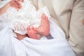 legs newborn baby girl in the parent hands on a white background clothes Royalty Free Stock Photo