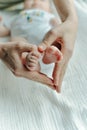 Legs newborn baby and Mama`s arms heart Royalty Free Stock Photo